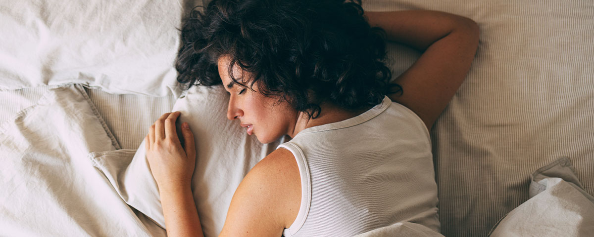 Eine Frau, die unruhiger in ihrem Bett schläft